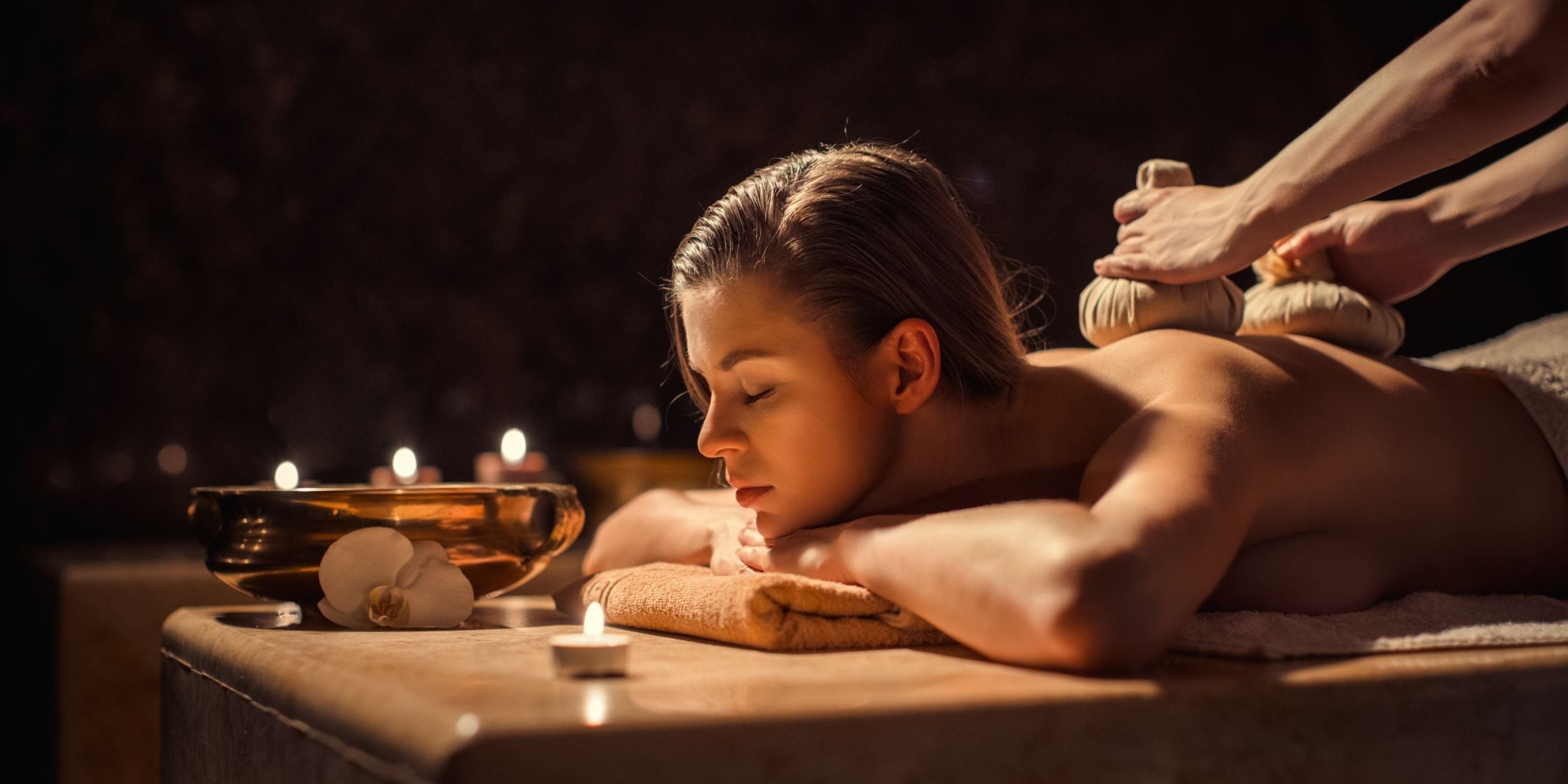 A woman relaxing and having a massage with candles burning