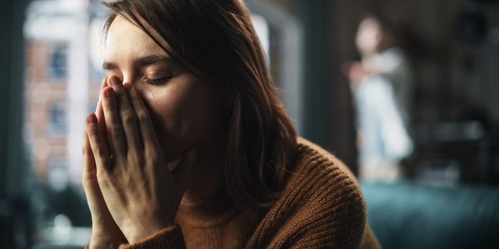A women with a dark background feeling stressed