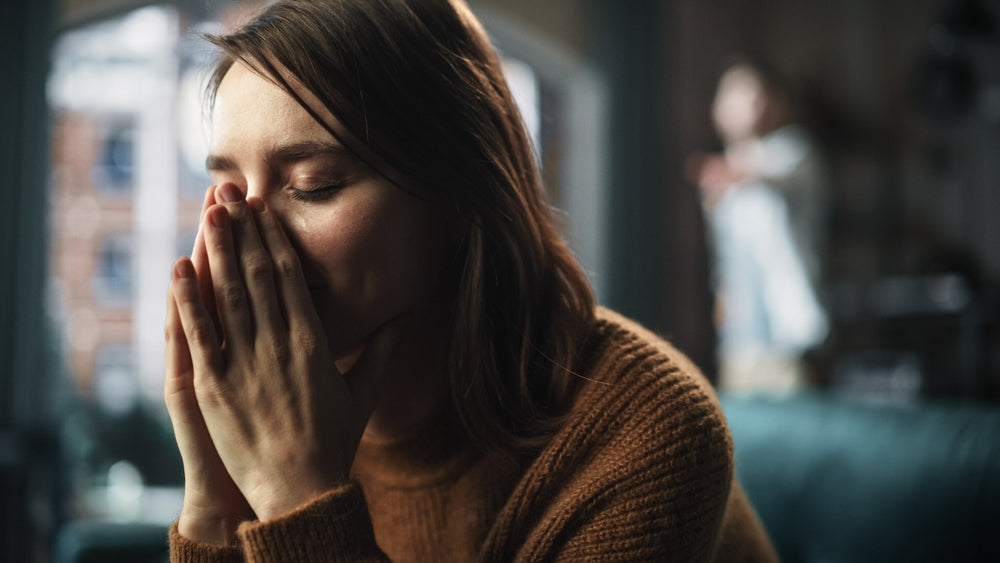 A women with a dark background feeling stressed