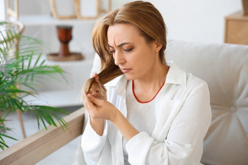 A women holding her hair and thinking how to nuture her hair