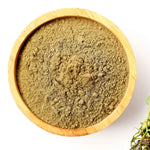 Wooden bowl filled with Centella powder on a white background