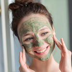 Woman applying Amla facial mask to her face