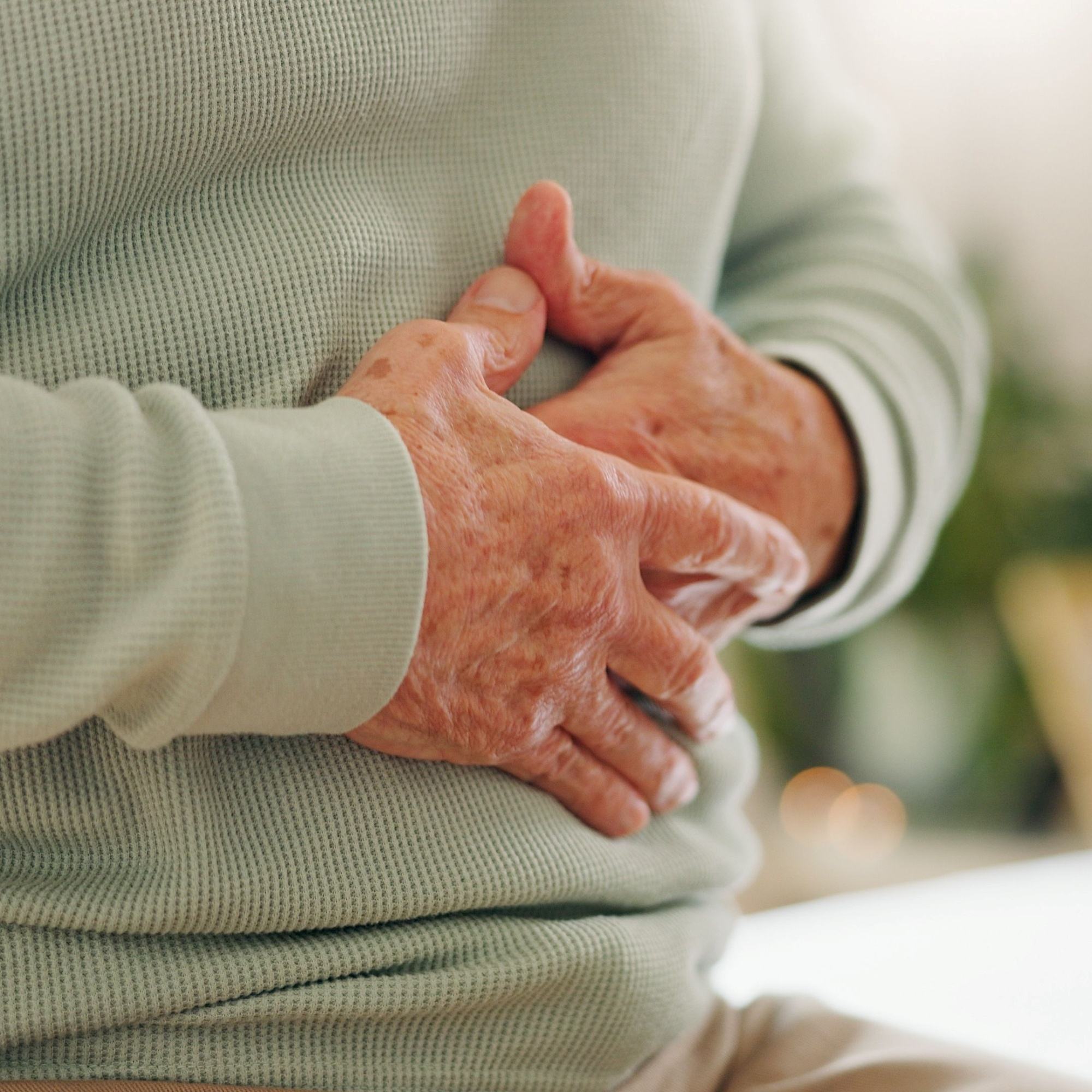Older Person Holding Tummy Natural Gut Health and Digestive Support Ayumi Neem & Karela Capsules UK