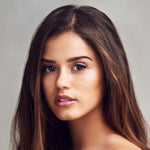 Woman with long brown hair against a neutral background