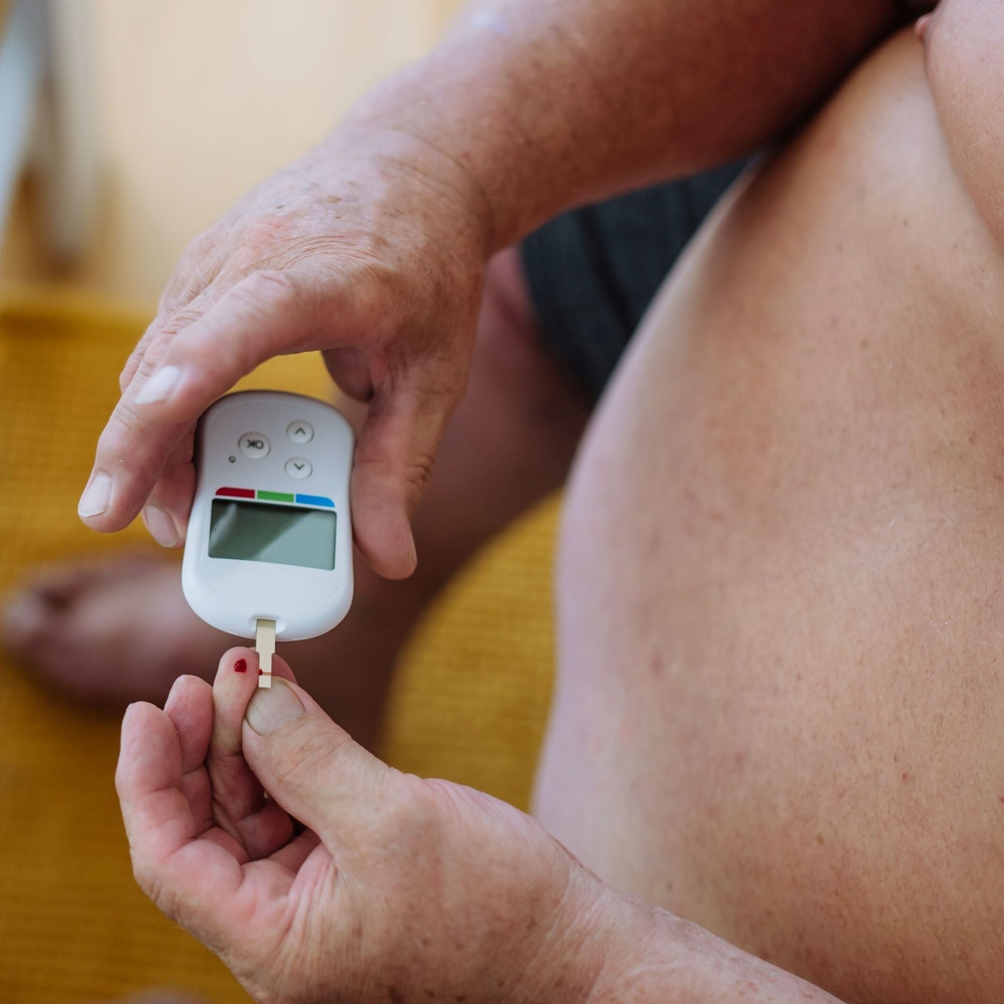 Person using a blood glucose meter on their finger.