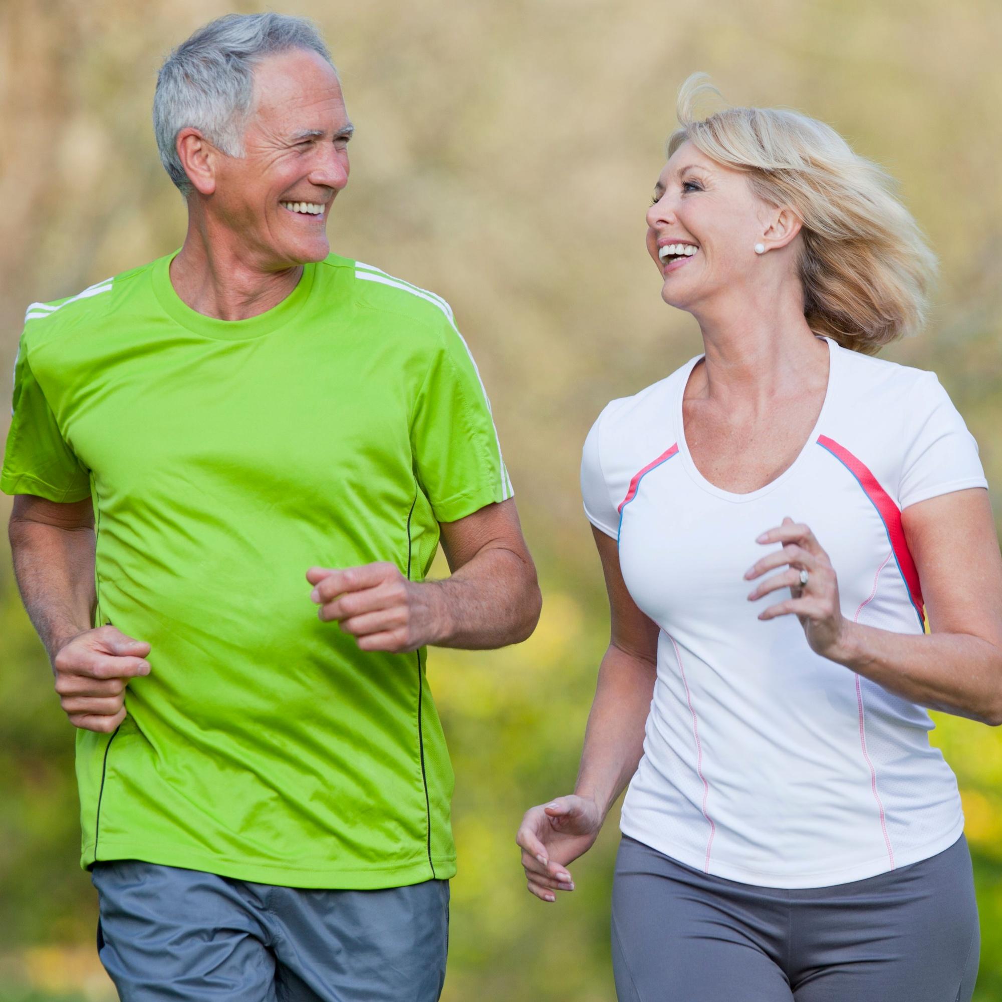 Man and woman jogging outdoors with a blurred natural background