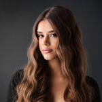 Woman with long, wavy hair against a dark background