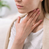 Woman touching her neck with a blurred background