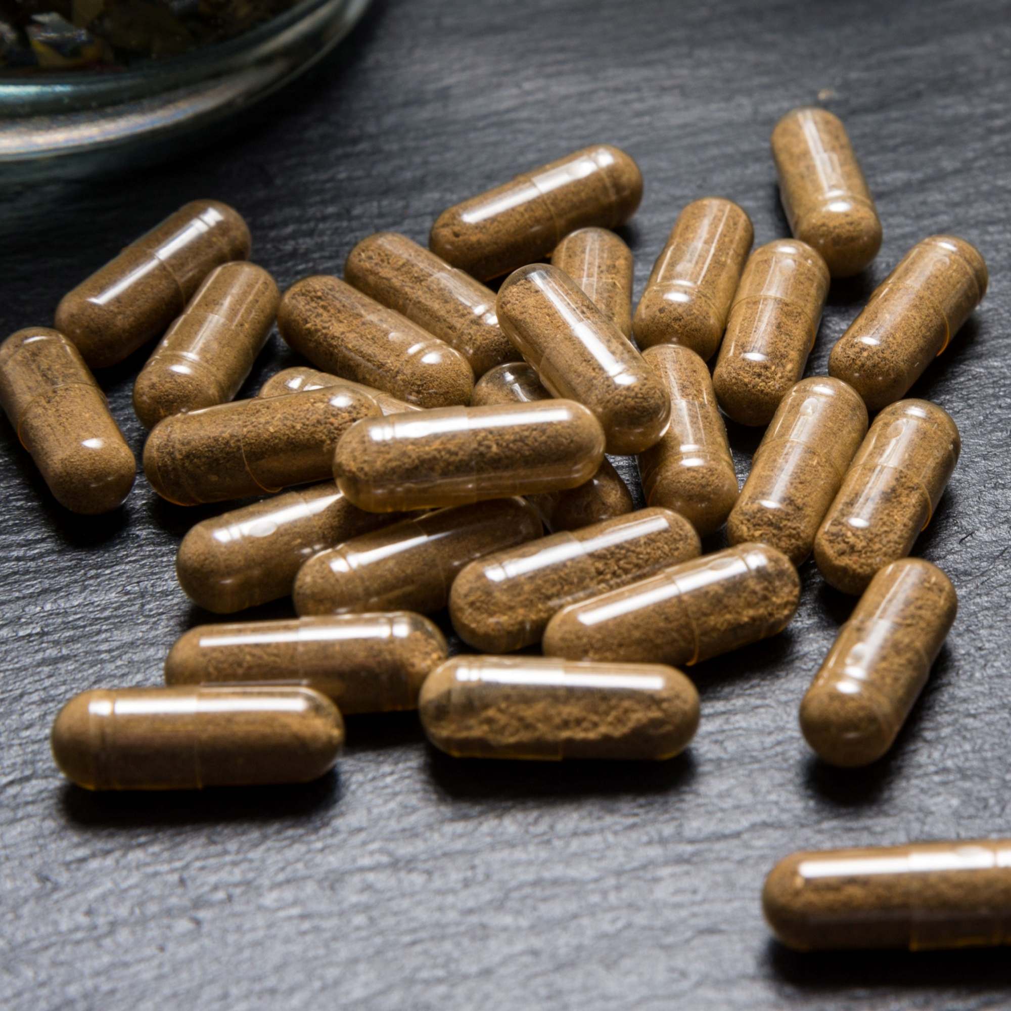 Guduchi capsules on a dark surface for Immunity