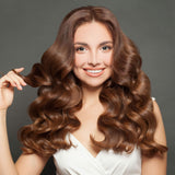 Woman with long, wavy brown hair against a gray background